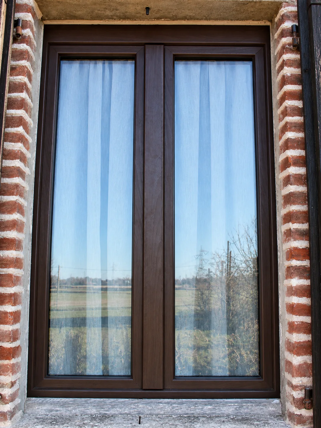 Finestra in PVC effetto legno installata su edificio in muratura